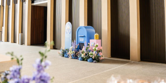 A display with a blue arch, branded signage "Good Eggs", and colorful flowers, creating a welcoming atmosphere for an Easter-themed event at Festival Tower